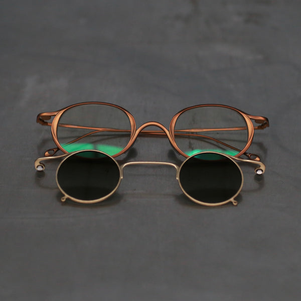 Rigards x ZIGGY CHEN RG1943ZC Titanium Magnetic Clip-On Sunglasses (RG-RG1943ZC-GTHGJKTMJLB) with antique bronze and gold frames, transparent lenses, and gradient green lenses.